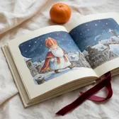 An open picture book with a watercolor of a bishop in a snowy town at night