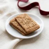 Speculaas cookies with windmill and ship patterns on a small white plate